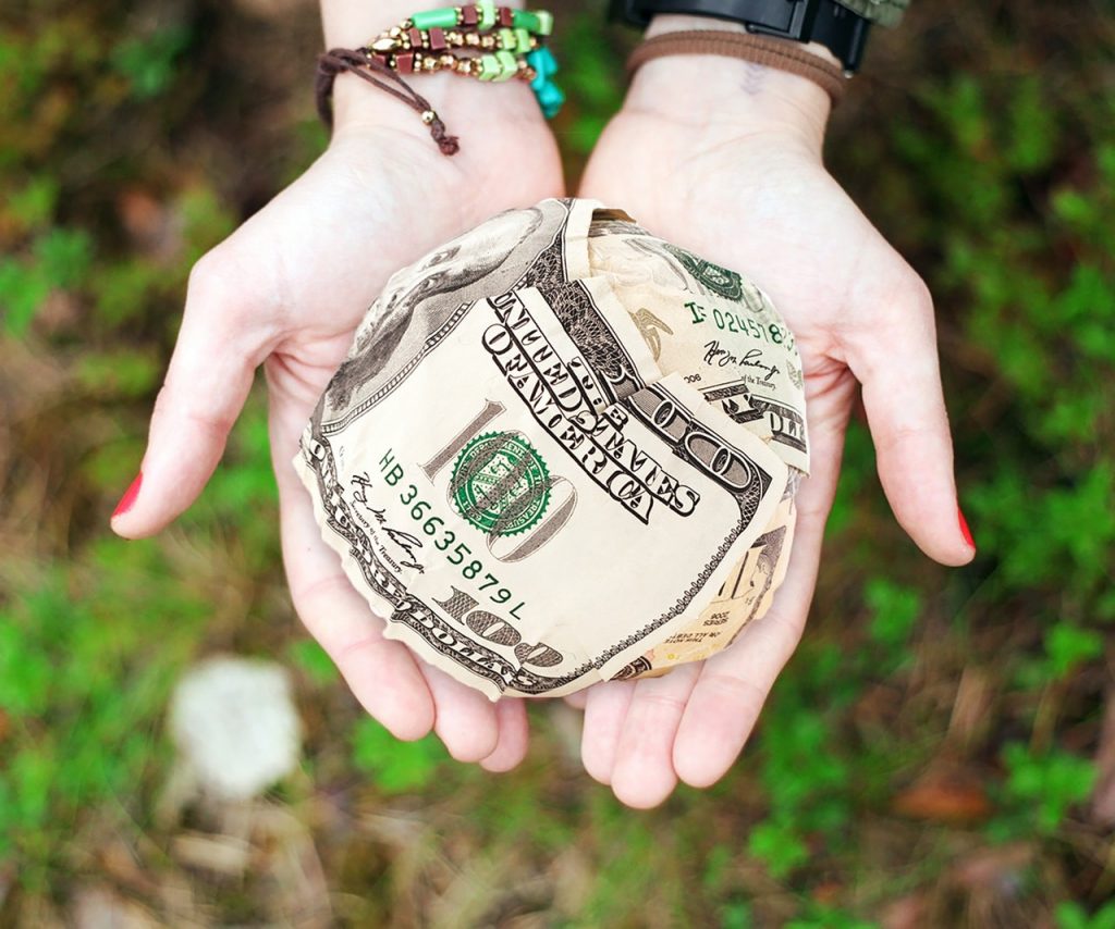 hands holding a small paper money