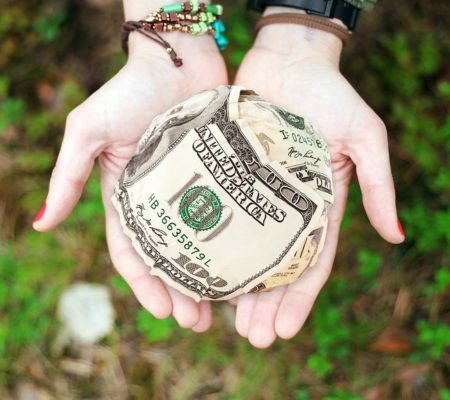 hands holding a small paper money