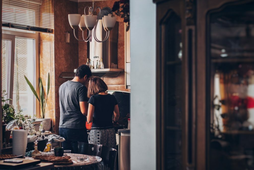a man and woman kissing in a kitchen