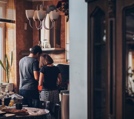 a man and woman kissing in a kitchen