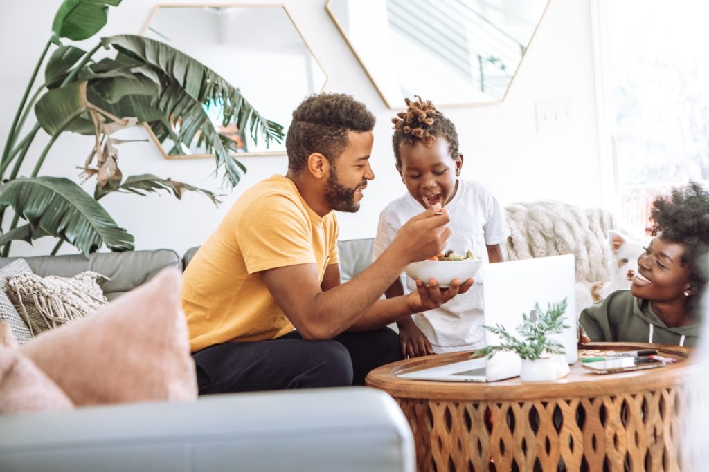 a man and a woman sitting on a couch and looking at a paper