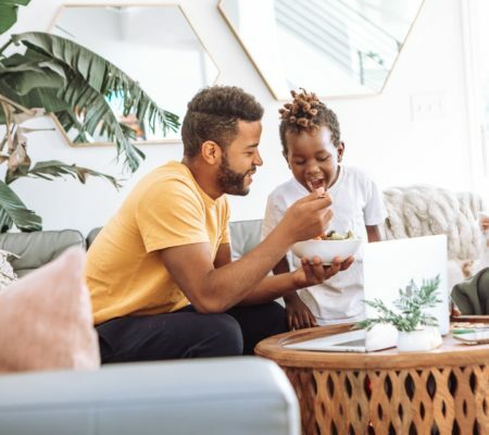 a man and a woman sitting on a couch and looking at a paper