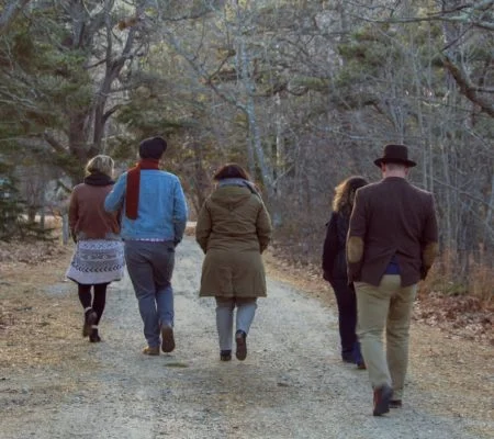 a group of people walking on a path in the woods