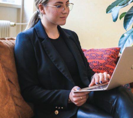 a person sitting on a couch with a laptop