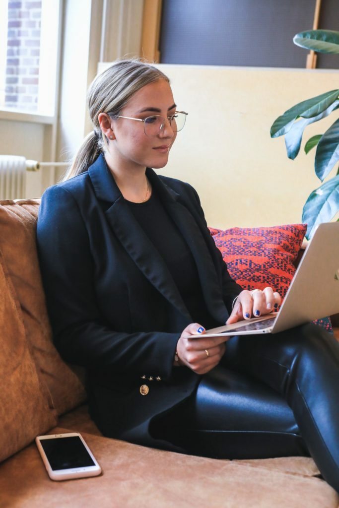 a person sitting on a couch with a laptop