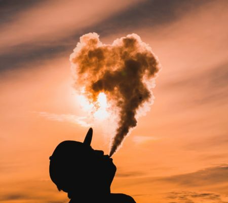 a silhouette of a hand holding a nuclear explosion