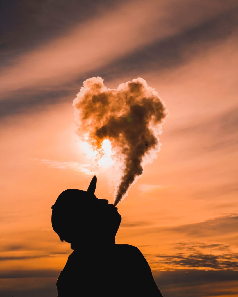 a silhouette of a hand holding a nuclear explosion