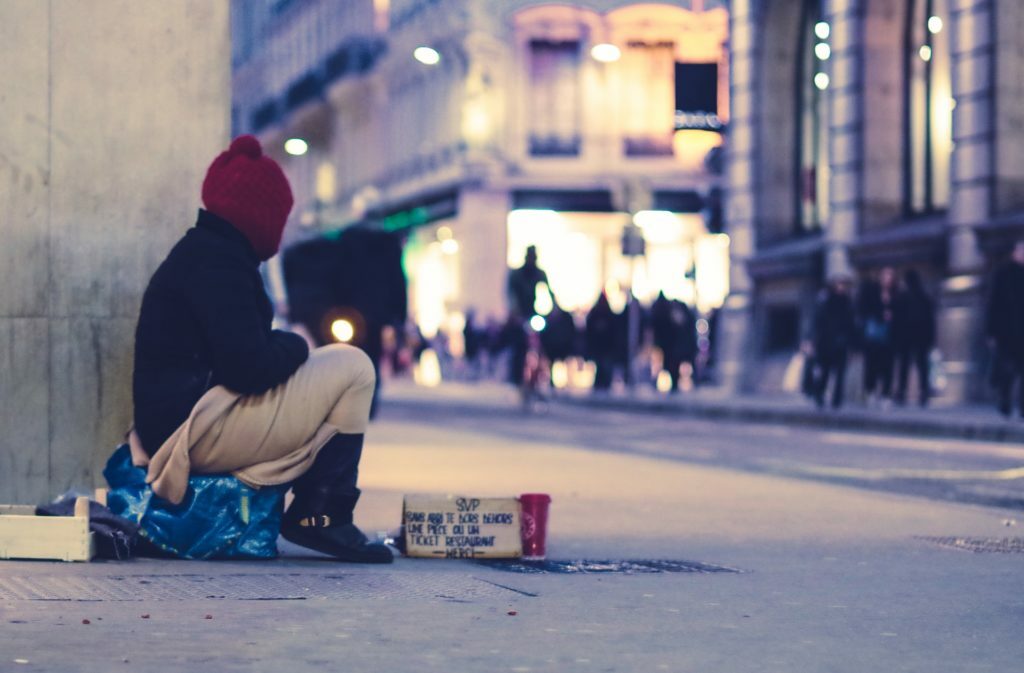 a man sitting on the sidewalk