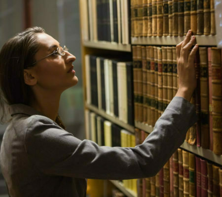 a woman in glasses looking at a book