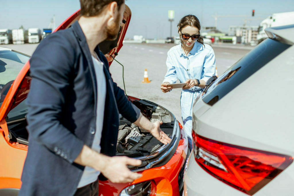 a man and a woman looking at a car engine