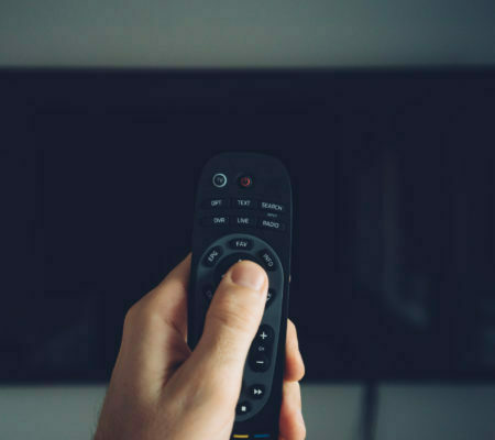 Male hand with TV remote controller